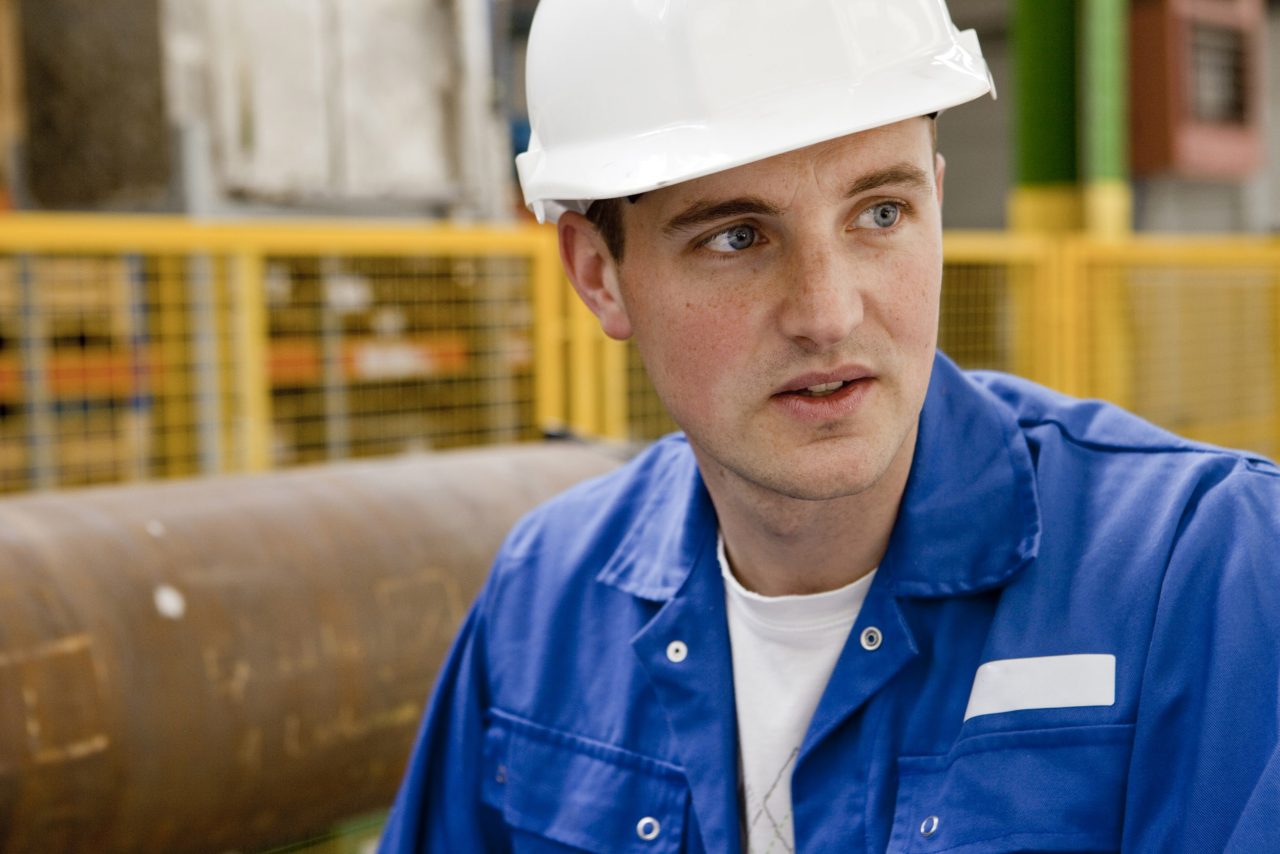 Photo industrielle de portrait métier d'un jeune homme casqué